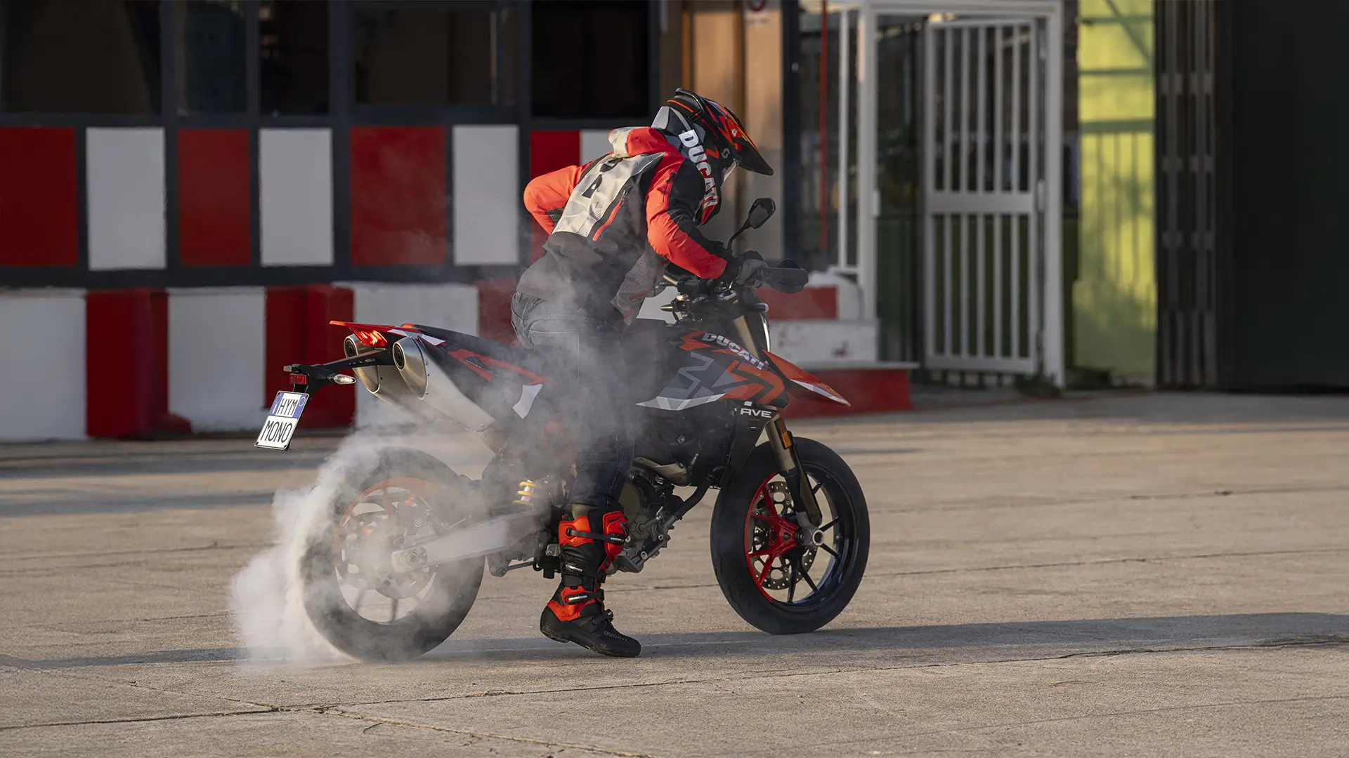 Ein Motorradfahrer macht einen Burnout mit einer Ducati auf einer asphaltierten Fläche.