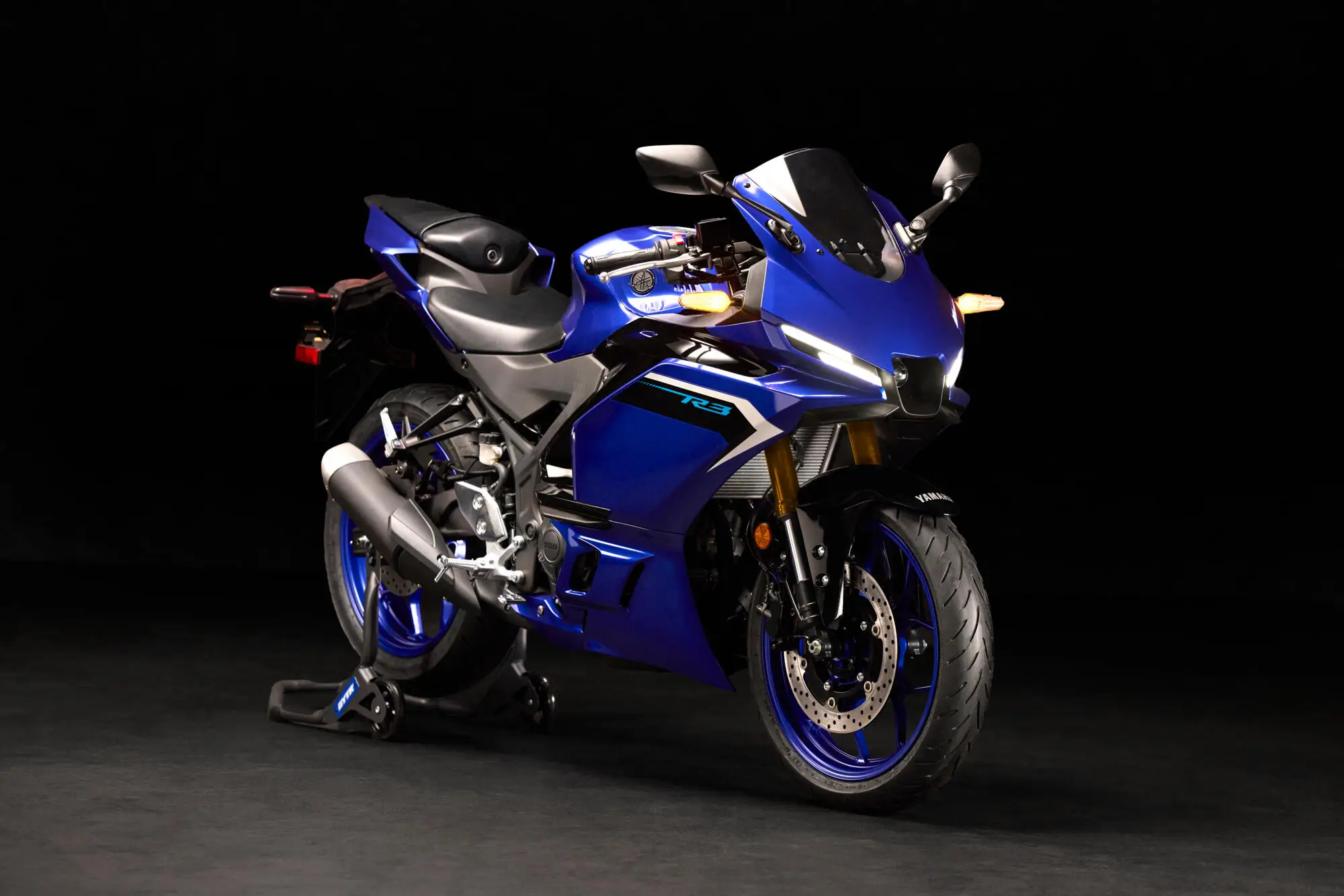 2025-Yamaha-YZF-R320-EU-Detail-009-03 Ein blaues Yamaha YZF-R320 Motorrad auf einem schwarzen Hintergrund.