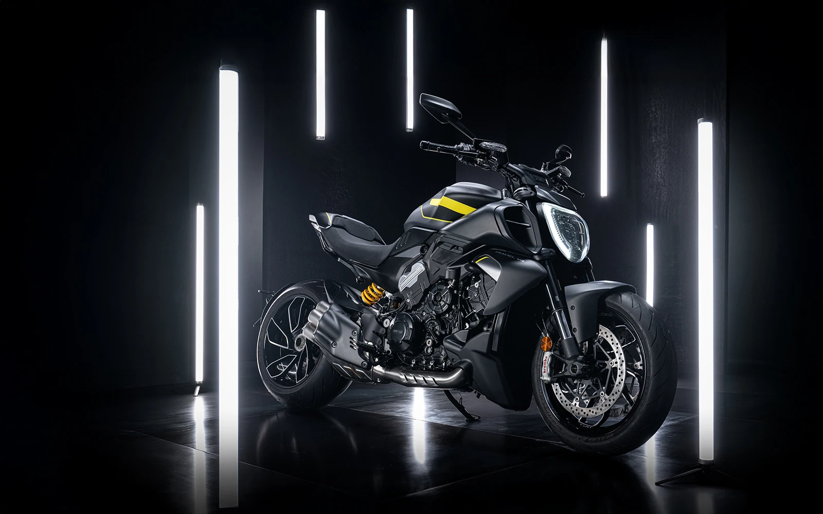 Ducati-Diavel-V4-overview-hero-1600x1000 Ducati Diavel V4 Motorrad in einem futuristischen Raum mit vertikalen Lichtern.