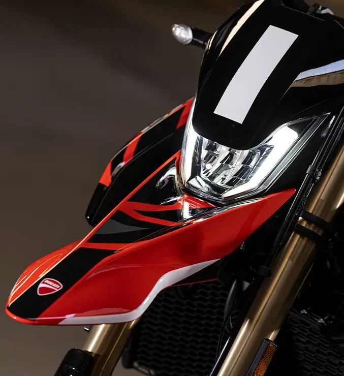 Ducati-Hypermotard-Mono-DWP24-Overview-carouse-imgtxt-677x740-04 Nahaufnahme der Front eines Ducati Hypermotard Motorrads mit markanter Scheinwerferform.