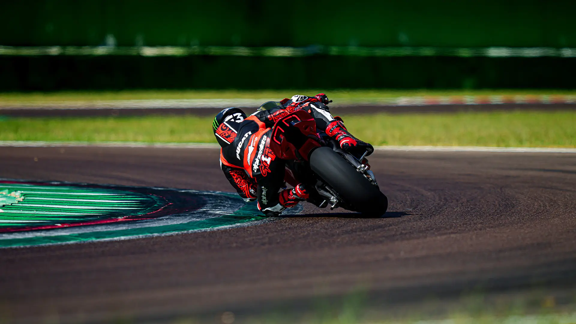 Motorradrennfahrer auf rotem Ducati Panigale V4 in scharfer Kurve.