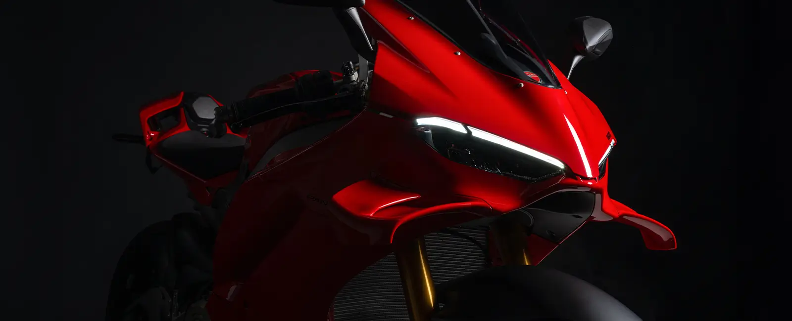Rotes Ducati Panigale V4 Motorrad von vorne in dunkler Umgebung.