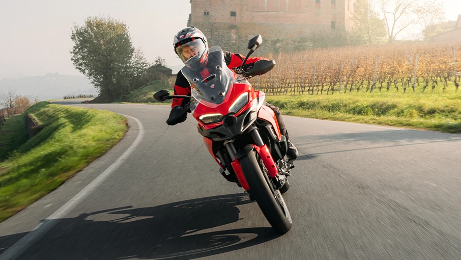 Ein Motorradfahrer fährt eine Ducati Multistrada V2 auf einer Landstraße.