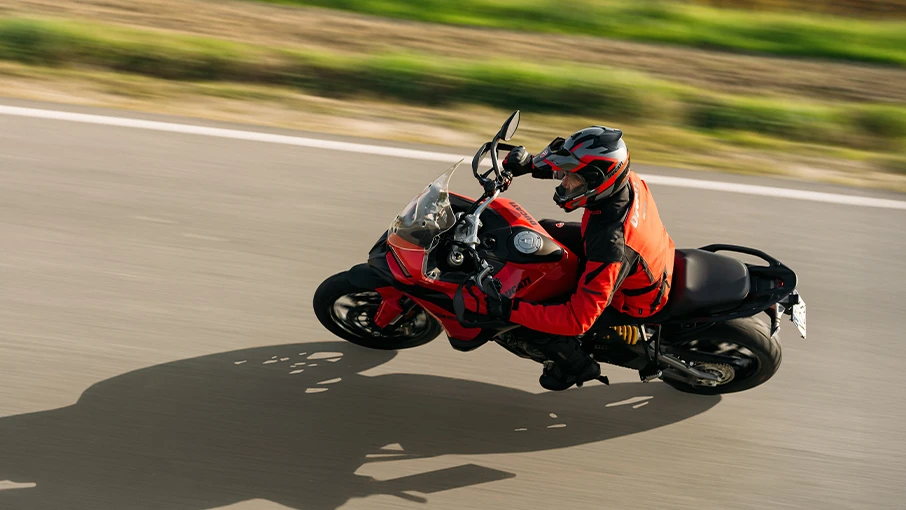 Ein Motorradfahrer auf einer Ducati Multistrada V2 fährt auf einer Straße.