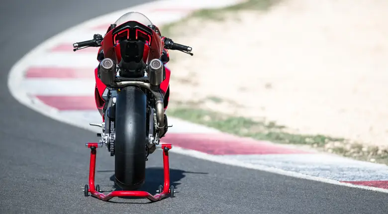 Ein rotes Ducati Panigale V2 Motorrad steht auf einem Rennstreckenständer.