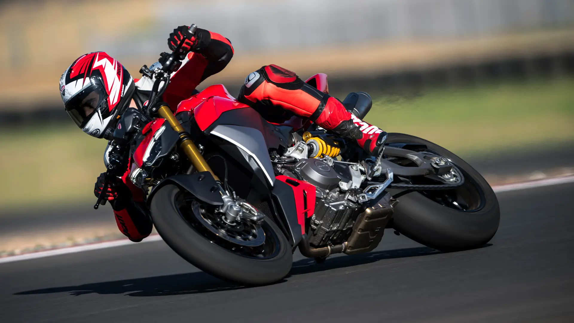Fahrer auf einer Ducati Streetfighter V2 in Kurvenlage auf der Rennstrecke.