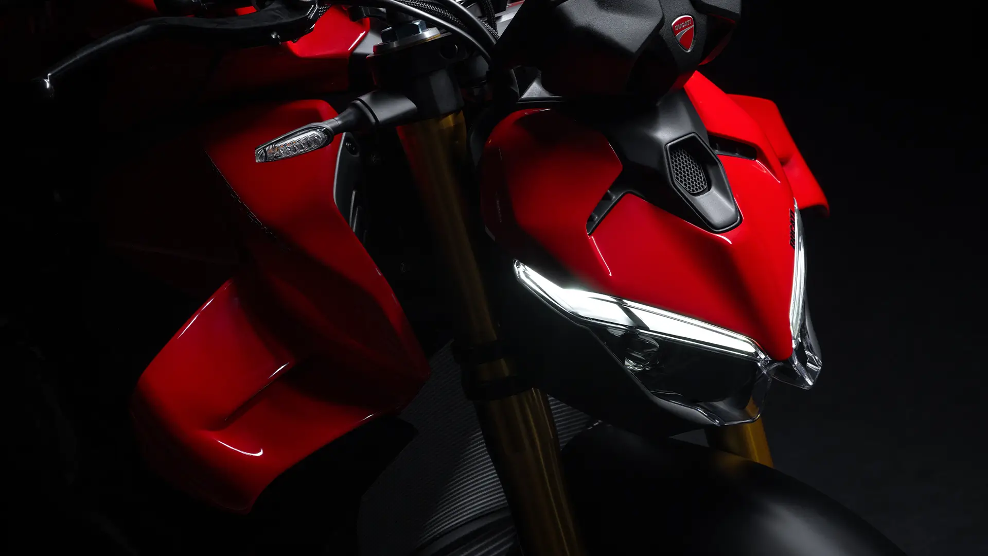 Nahaufnahme einer roten Ducati Streetfighter V4 mit sichtbaren Scheinwerfern und Lenkern.