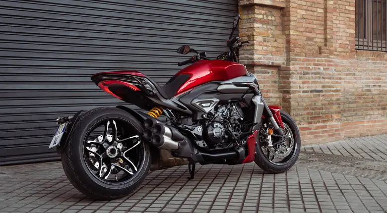 Ducati-XDiavel-V4-overview-mosaic-gallery-780x430-06 Ducati XDiavel V4 Motorrad steht vor einer Backsteinmauer.