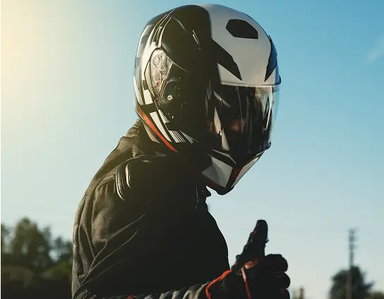 shop_helme Ein Motorradfahrer mit Helm zeigt einen Daumen hoch.