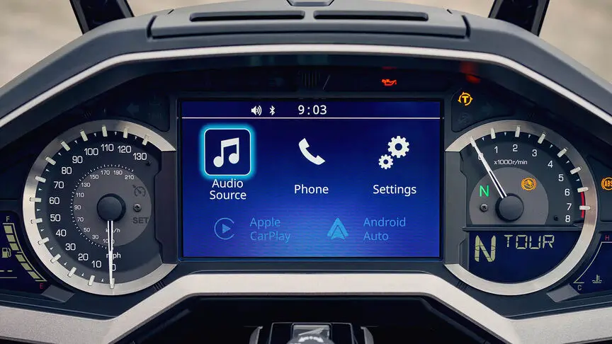 techno Cockpit-Anzeige eines Motorrads mit Tachometer, Drehzahlmesser und digitalem Bildschirm mit Audio-, Telefon- und Einstellungssymbolen.