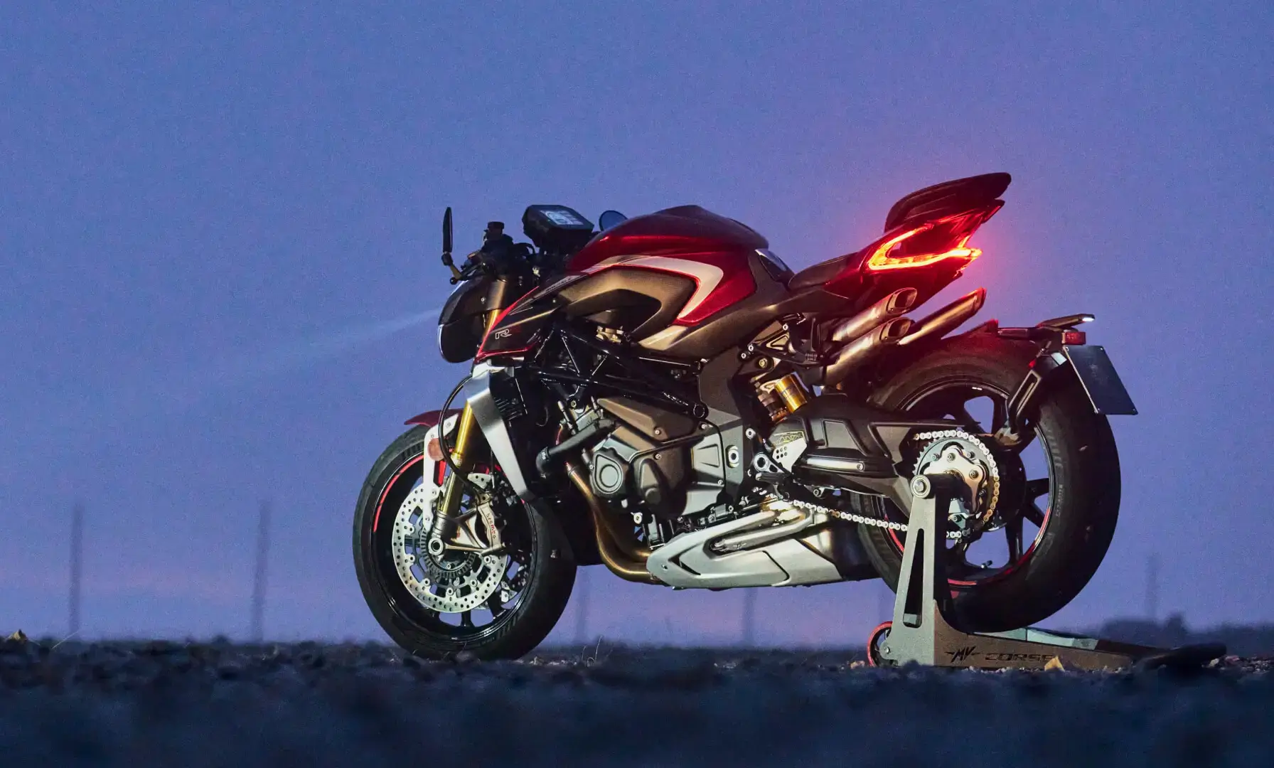 Ein rotes MV Agusta Motorrad steht auf einem Ständer bei Dämmerung.