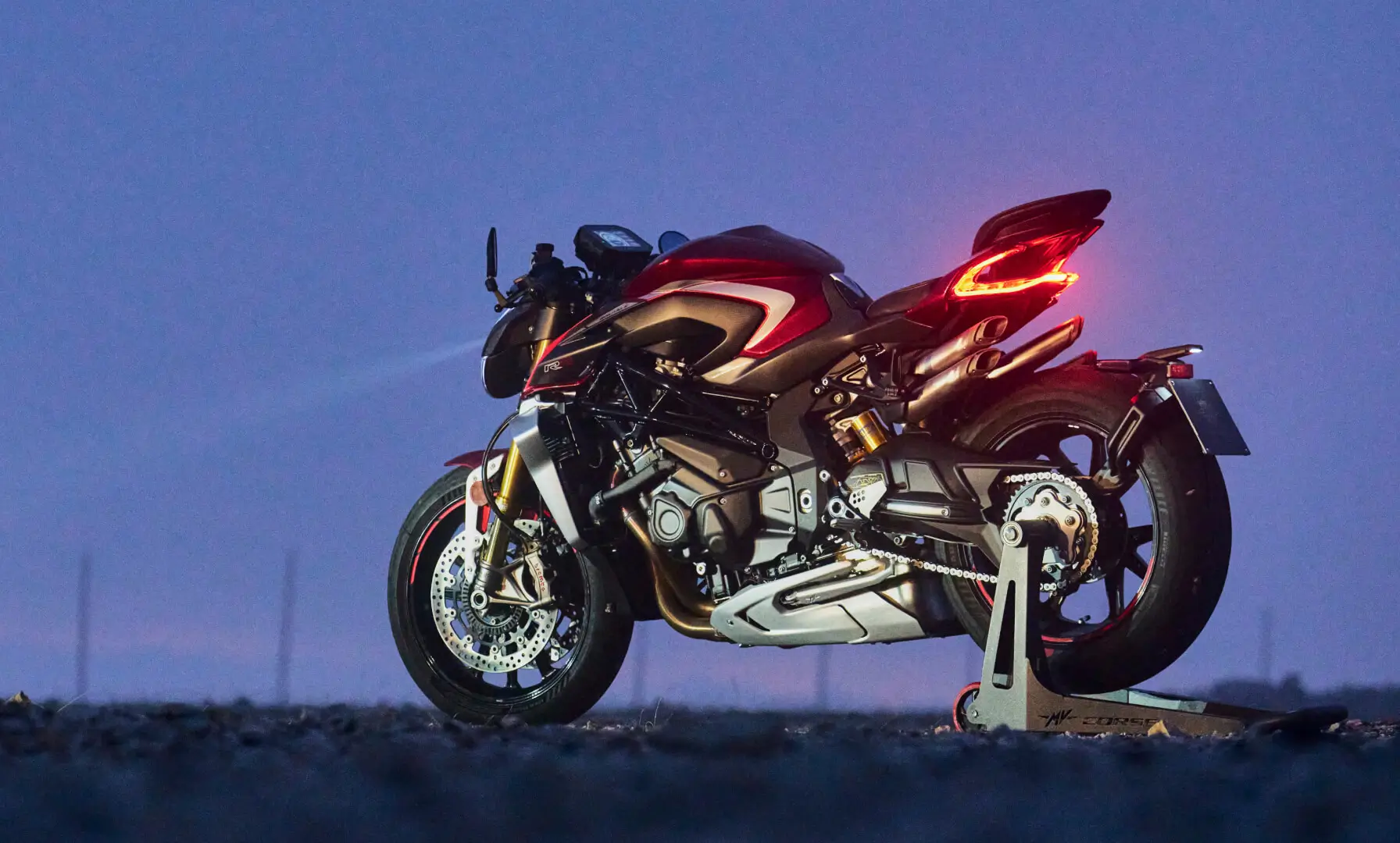 1 Eine rote MV AGUSTA BRUTALE 1000 RR steht auf einem Ständer bei Dämmerung.