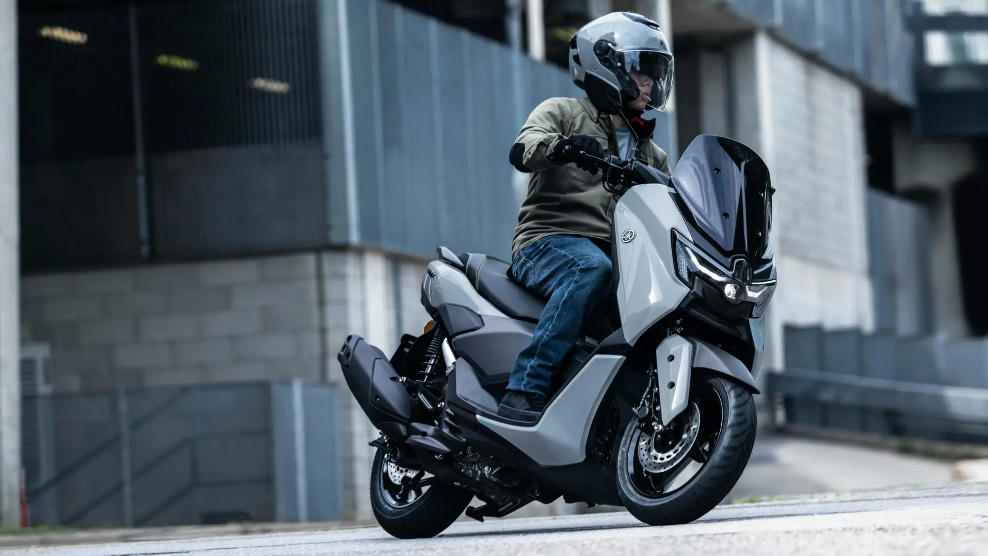 Ein Mann fährt einen 2025 Yamaha NMAX 125 Tech MAX Roller.