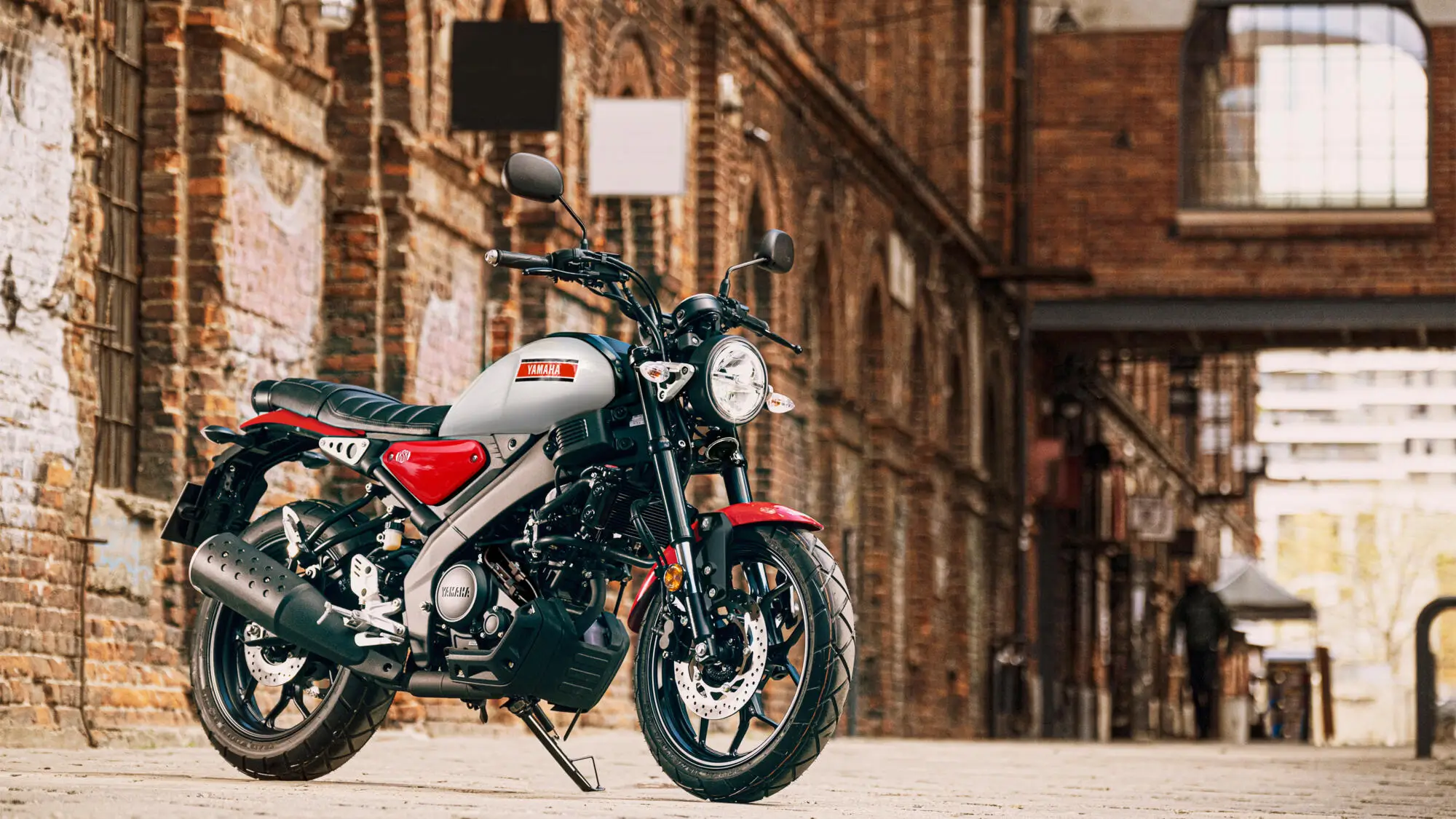 Ein Yamaha XS125 Motorrad steht vor einer Backsteinmauer.