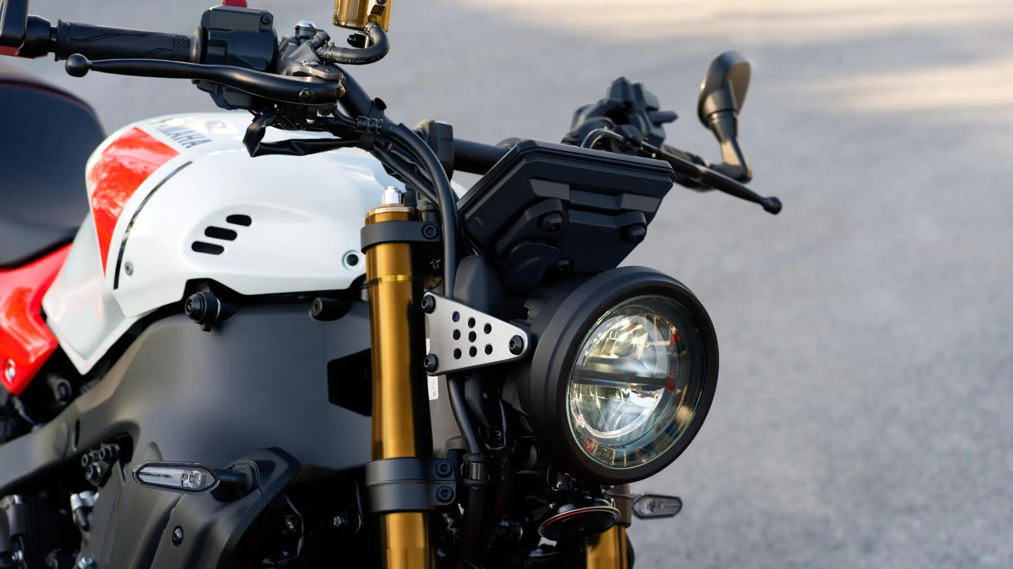 Nahaufnahme des Frontbereichs einer Yamaha XSR900 mit Scheinwerfer und Lenkstange.
