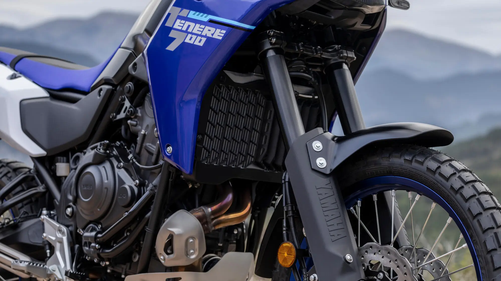 Nahaufnahme einer blauen Yamaha Tenere 700 mit sichtbarem Motor und Vorderreifen.