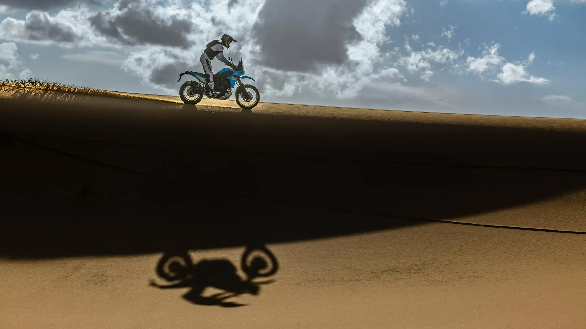 Ein Motorradfahrer fährt mit einer Yamaha XTZ700SPR über eine Sanddüne.