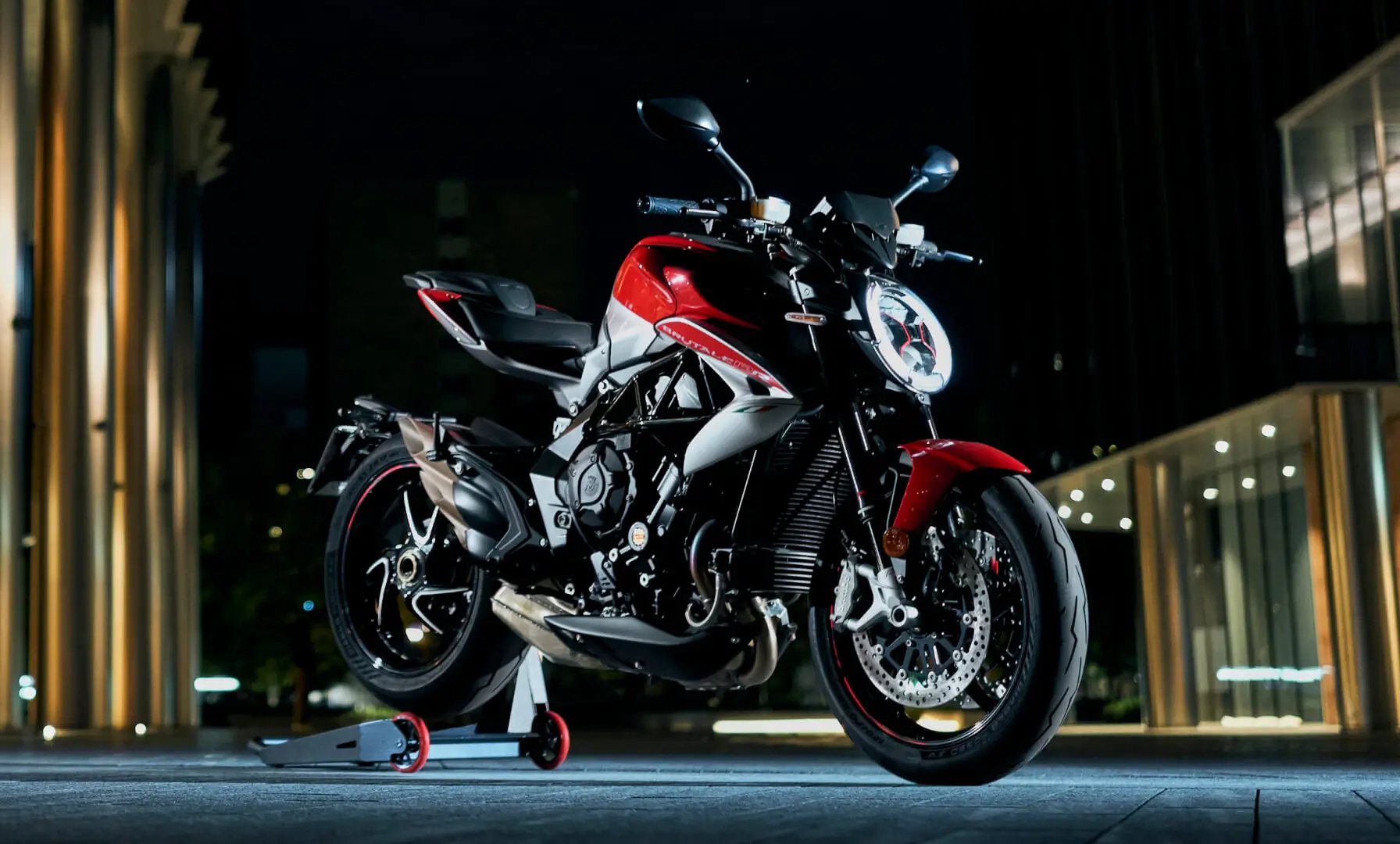 Ein rotes MV Agusta Brutale Motorrad steht auf einem Ständer bei Nacht.