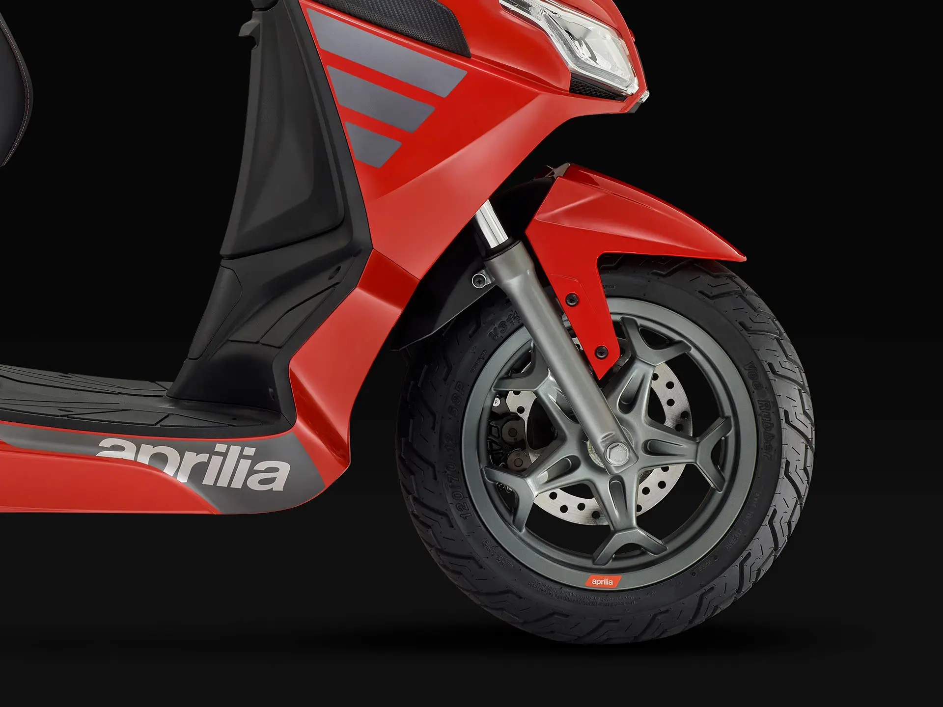 Rotes Vorderrad eines Aprilia SXR Sport 50 Rollers auf schwarzem Hintergrund.
