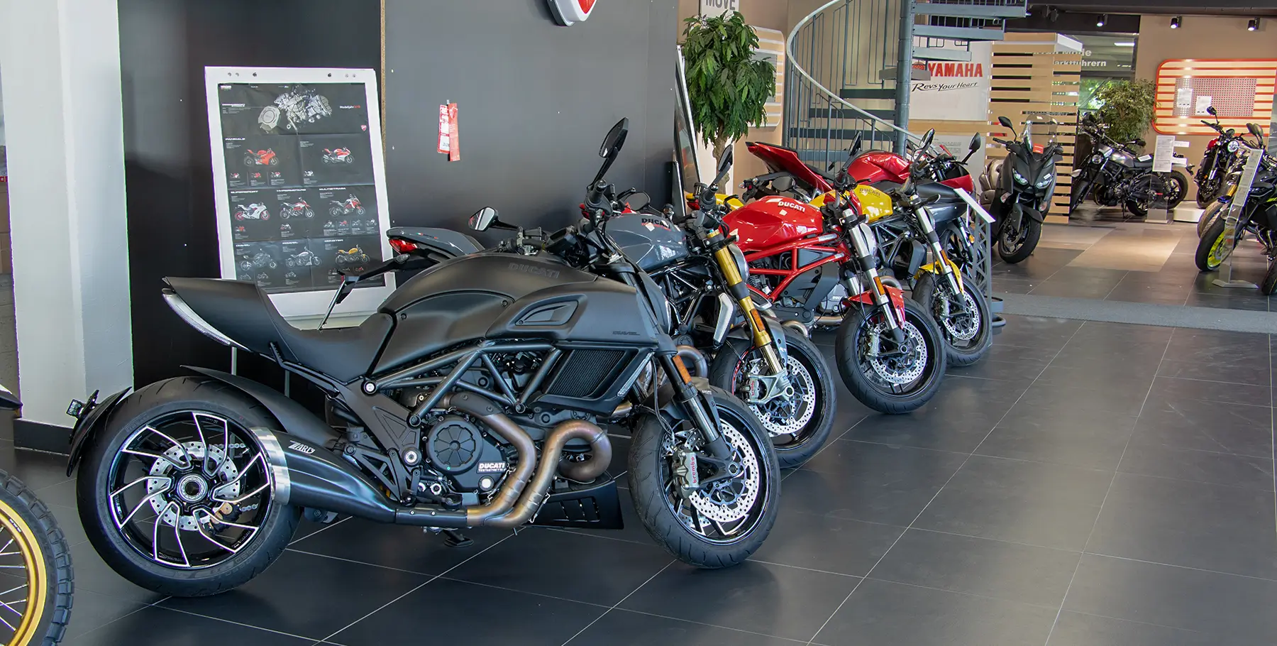 Eine Reihe von Ducati-Motorrädern steht in einem Ausstellungsraum.