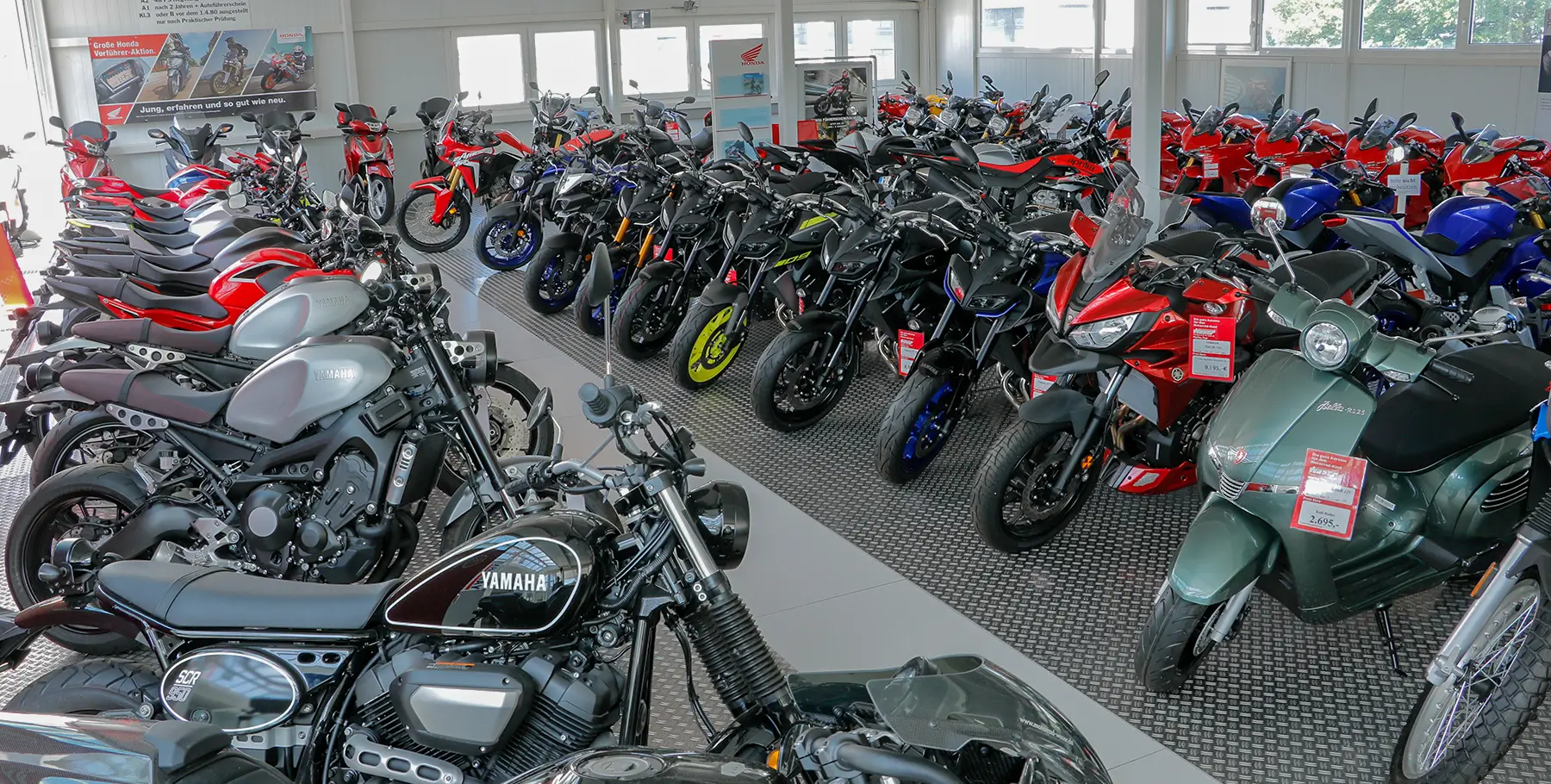 Eine Ausstellungshalle mit verschiedenen Motorrädern, darunter Yamaha-Modelle.