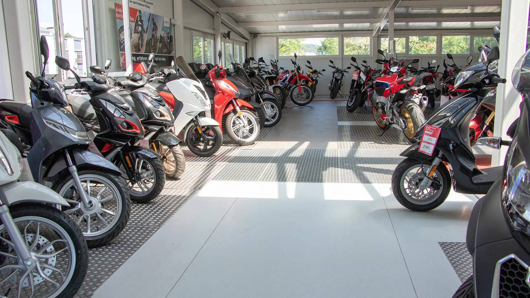 Ein Ausstellungsraum voller verschiedener Motorräder und Roller.