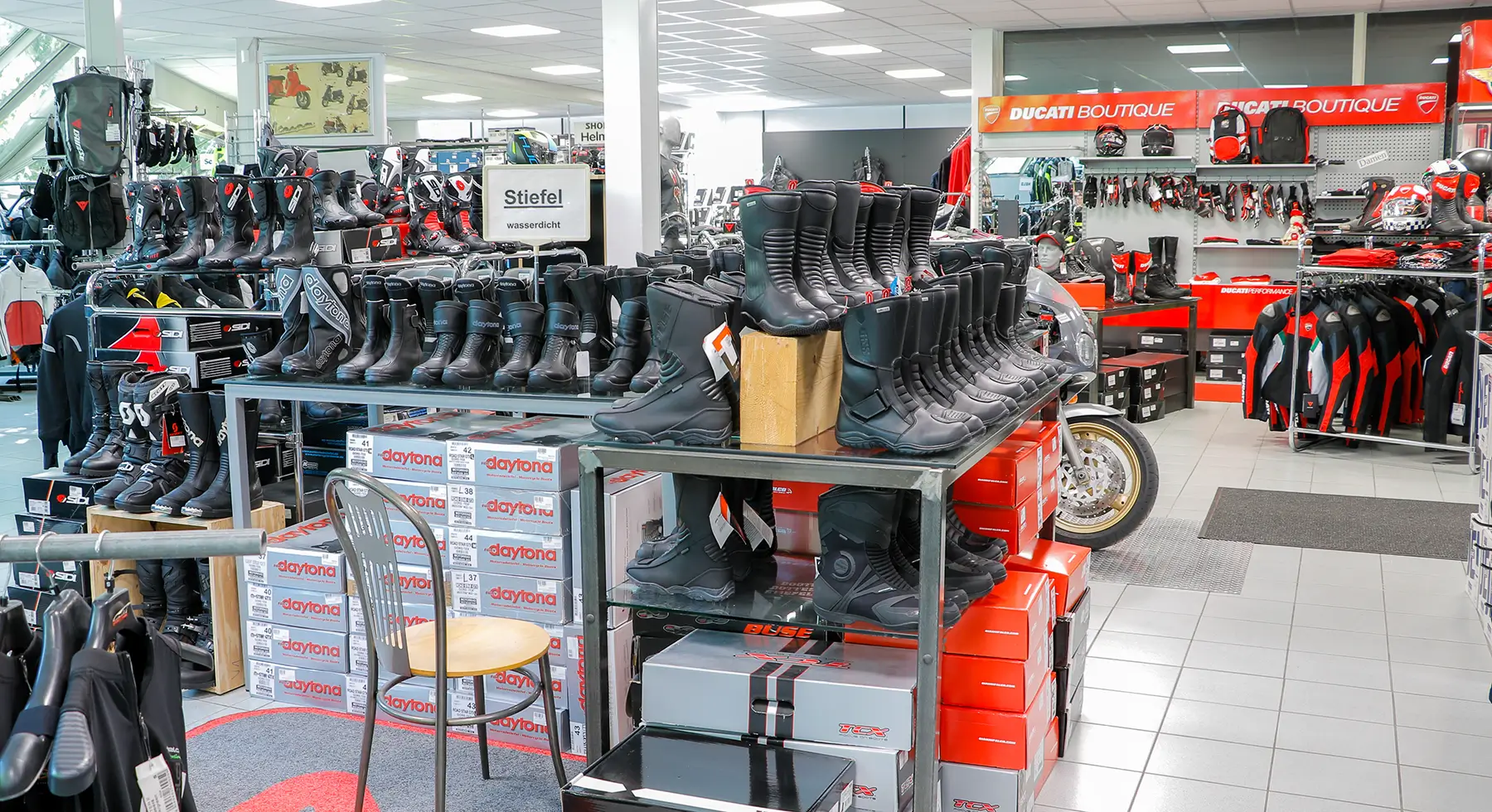 Motorradgeschäft mit einer Auswahl an Motorradstiefeln und Ducati-Bekleidung.