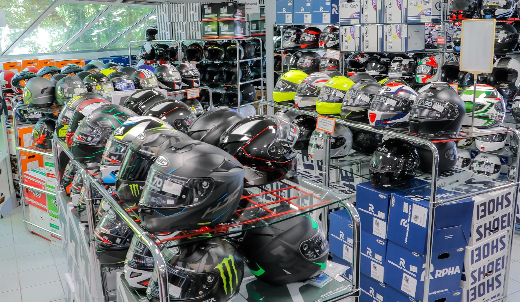 Bei Motorrad Waser viele Regalen voller Motorradhelme.
