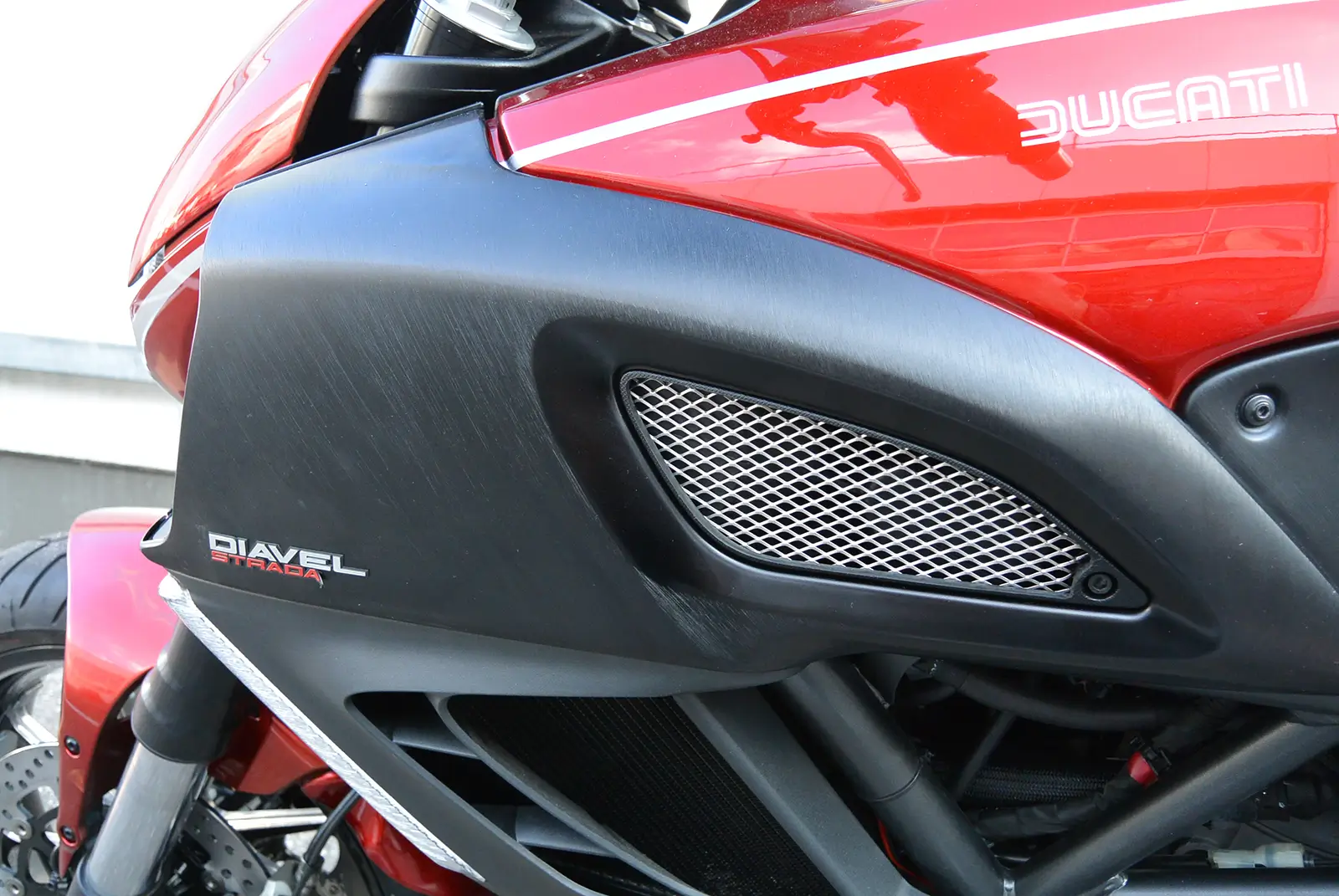 Ein rotes Ducati Diavel Strada Motorrad mit seitlichem Detail der Verkleidung.
