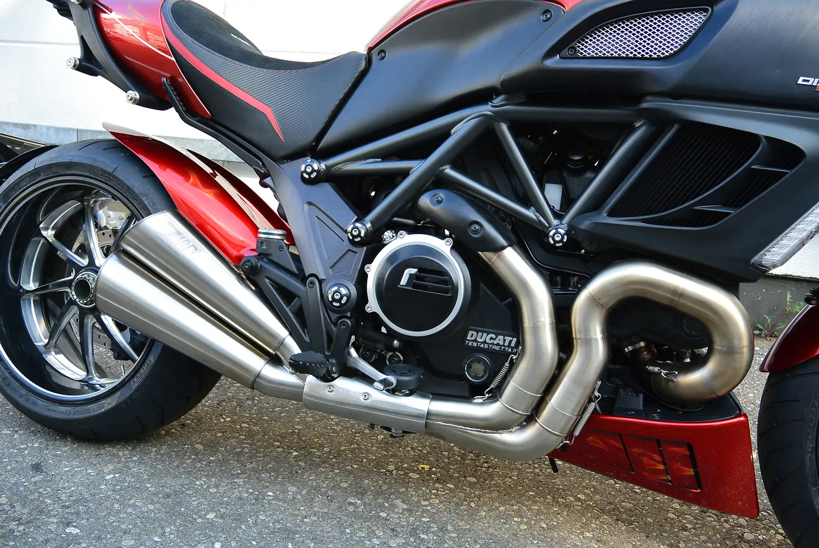 Ducati-Motorrad mit markantem Auspuff und rotem Rahmen.