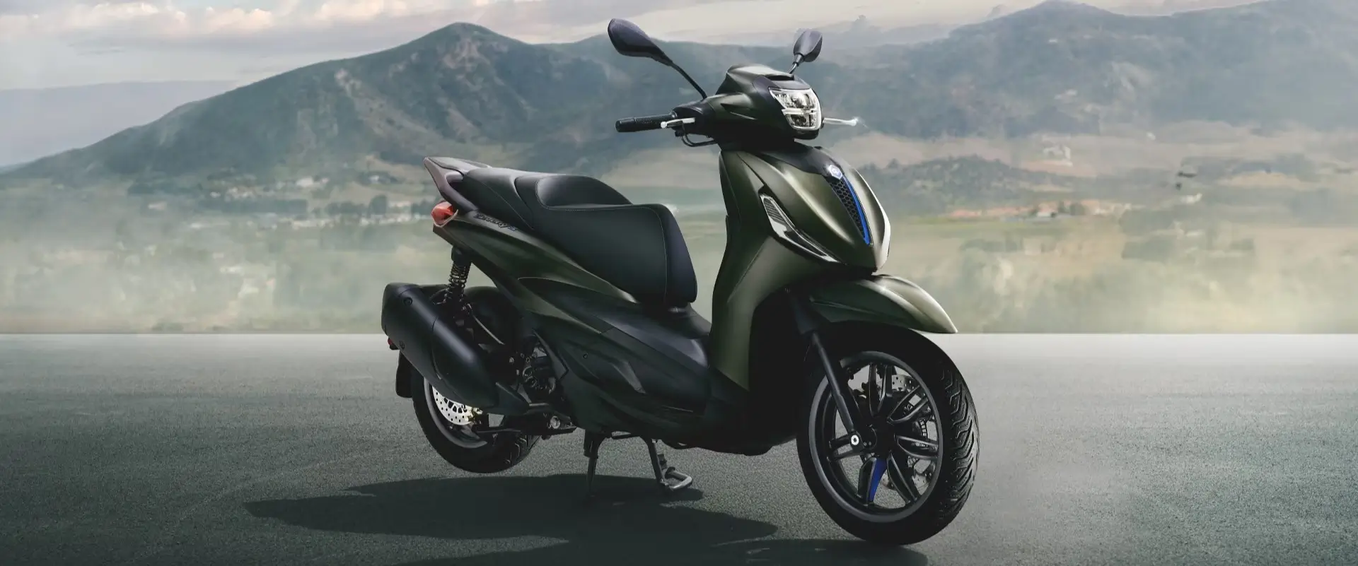 Ein Piaggio Beverly Roller steht vor einer Berglandschaft.