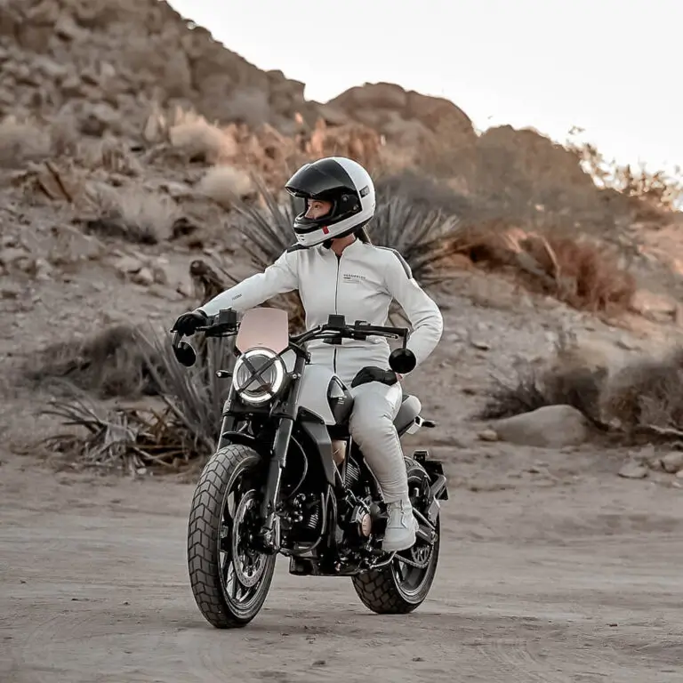 Scrambler-Ducati-10°-Anniversario-Rizoma-Edition-MY25-flexicard-1080x1080-03-768x768 Fahrer auf einer Scrambler Ducati 10° Anniversario Rizoma Edition in einer Wüstenlandschaft.