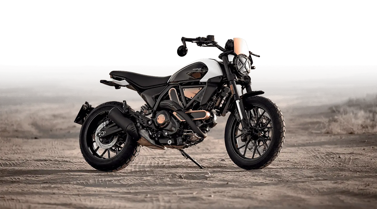 Ducati Scrambler 10° Anniversario Rizoma Edition Motorrad auf sandigem Untergrund.