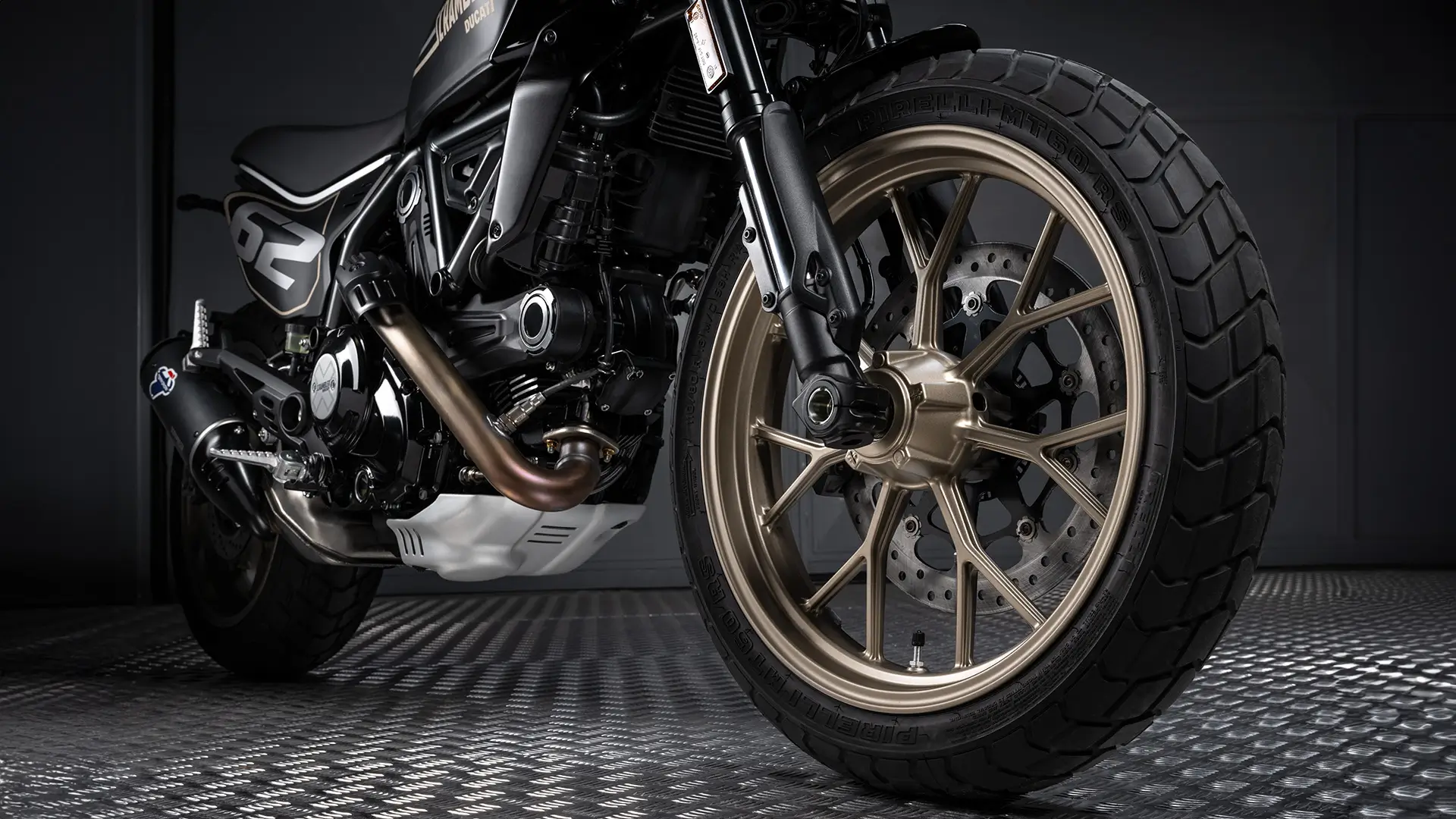 Nahaufnahme eines Ducati Scrambler Full Throttle Motorrads, Fokus auf dem Vorderrad und Motor.