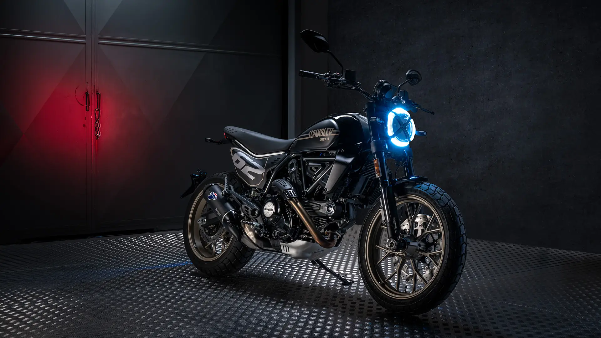 Ducati Scrambler Full Throttle Motorrad mit blauem Scheinwerfer in einer dunklen Umgebung.