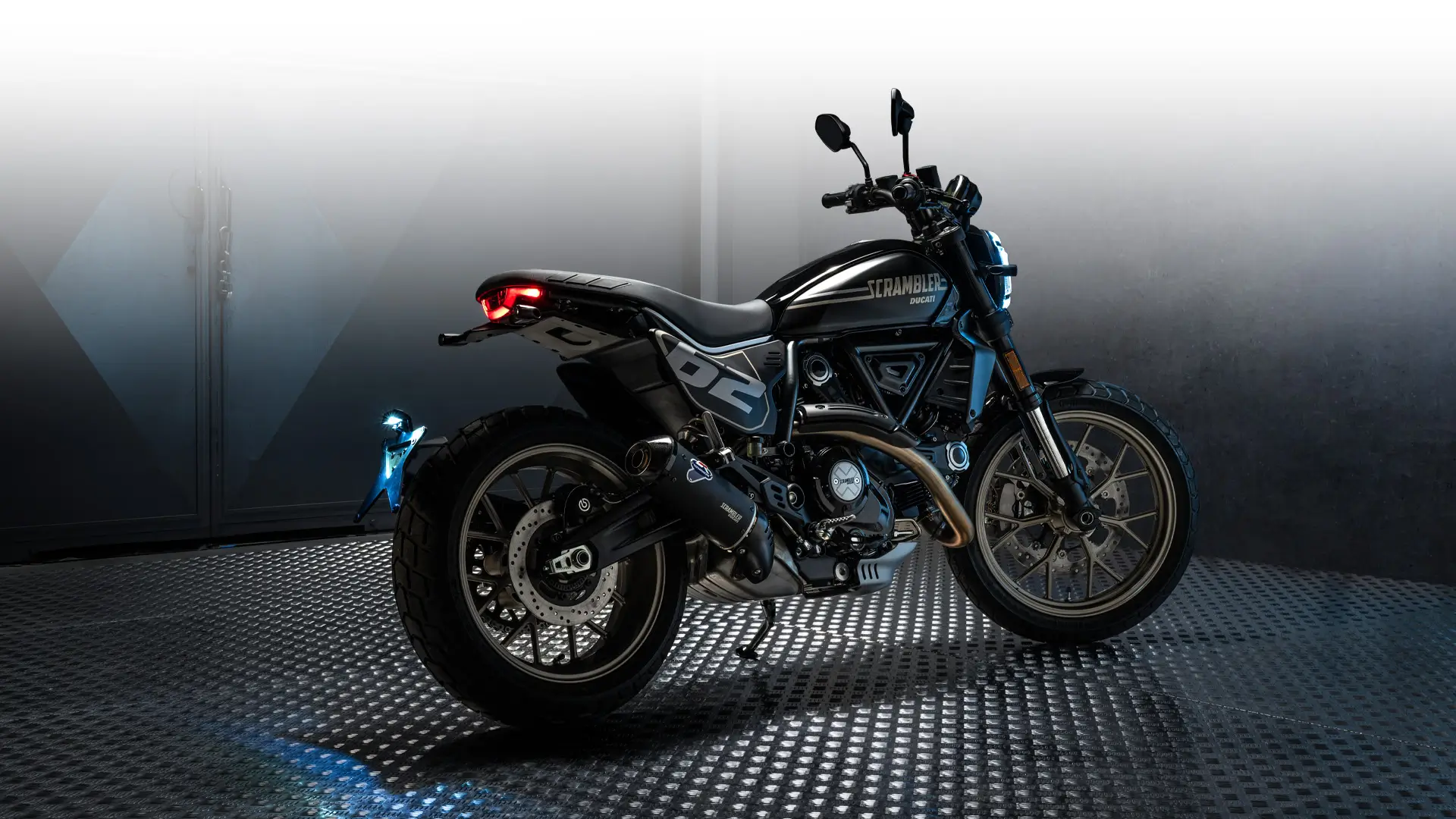 Ein schwarzes Ducati Scrambler Full Throttle Motorrad steht auf einem Metallboden.