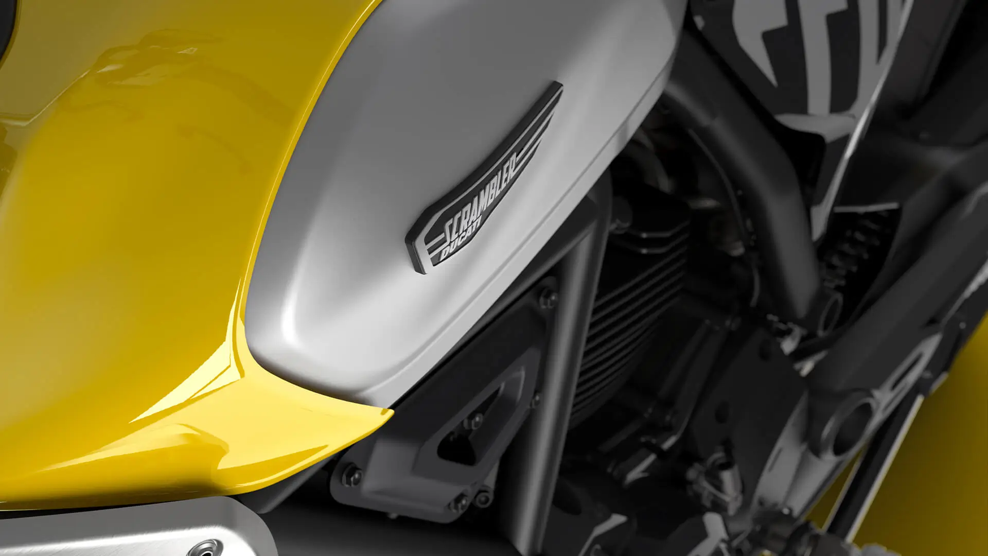 Nahaufnahme eines gelben Ducati Scrambler Motorrads mit sichtbarem Markenlogo.