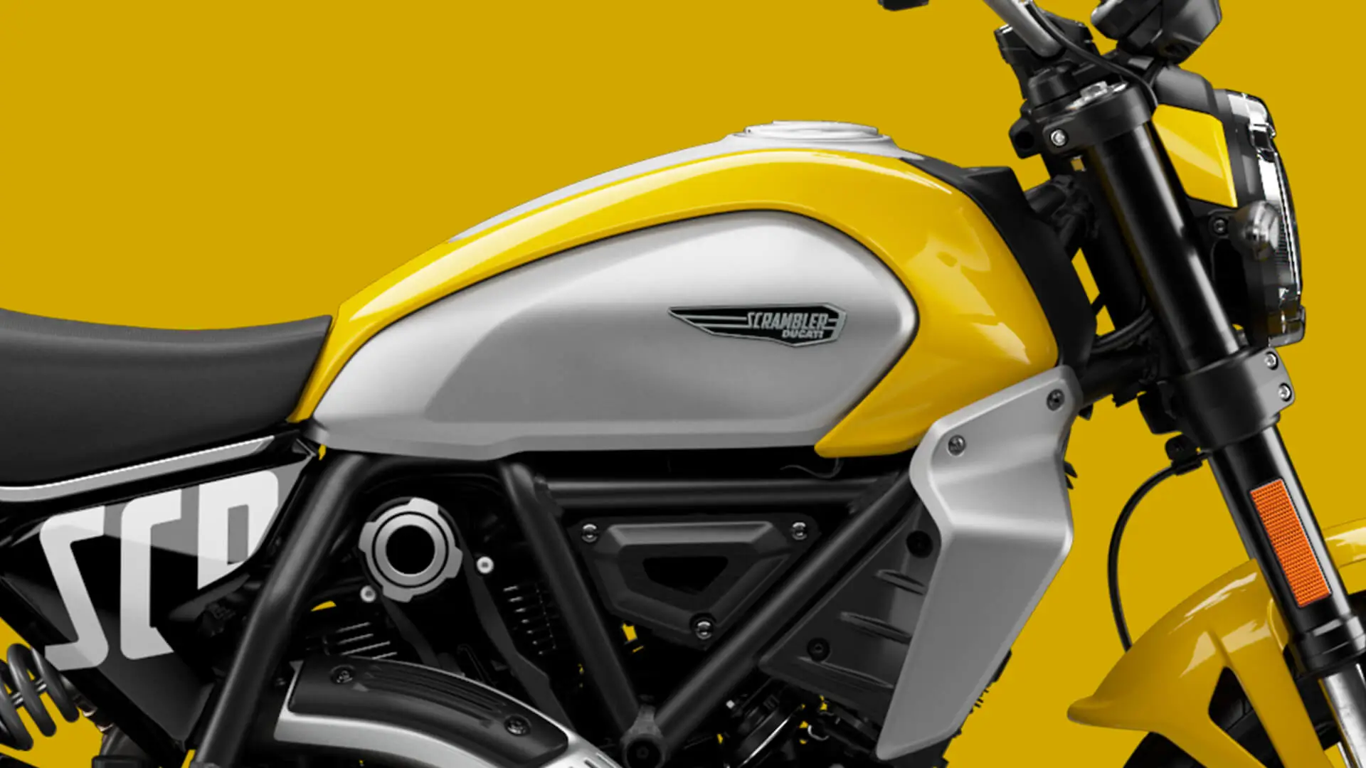 Gelbes und silbernes Ducati Scrambler Icon seitlich vor gelbem Hintergrund.