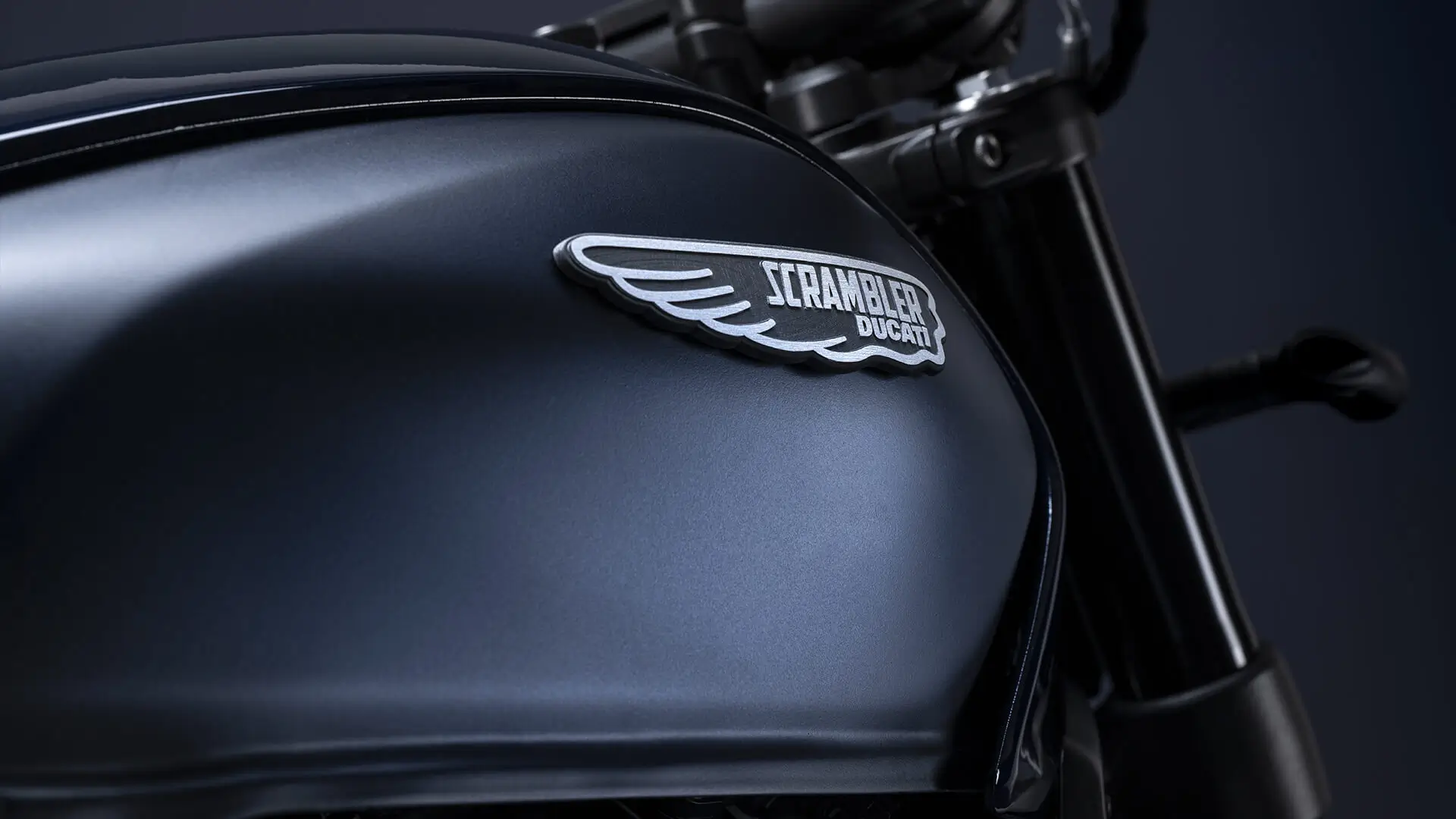 Nahaufnahme des Tanks einer Ducati Scrambler mit Logo.