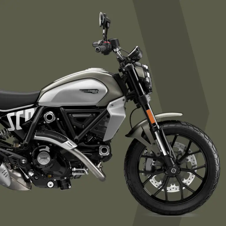 Ein Scrambler-Motorrad in der Farbe Storm Green seitlich auf grauem Hintergrund.