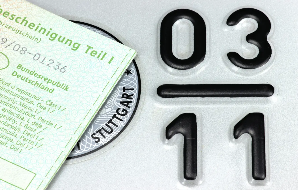 Zulassung Motorrad Zulassungsbescheinigung und TÜV-Plakette auf einem Nummernschild.