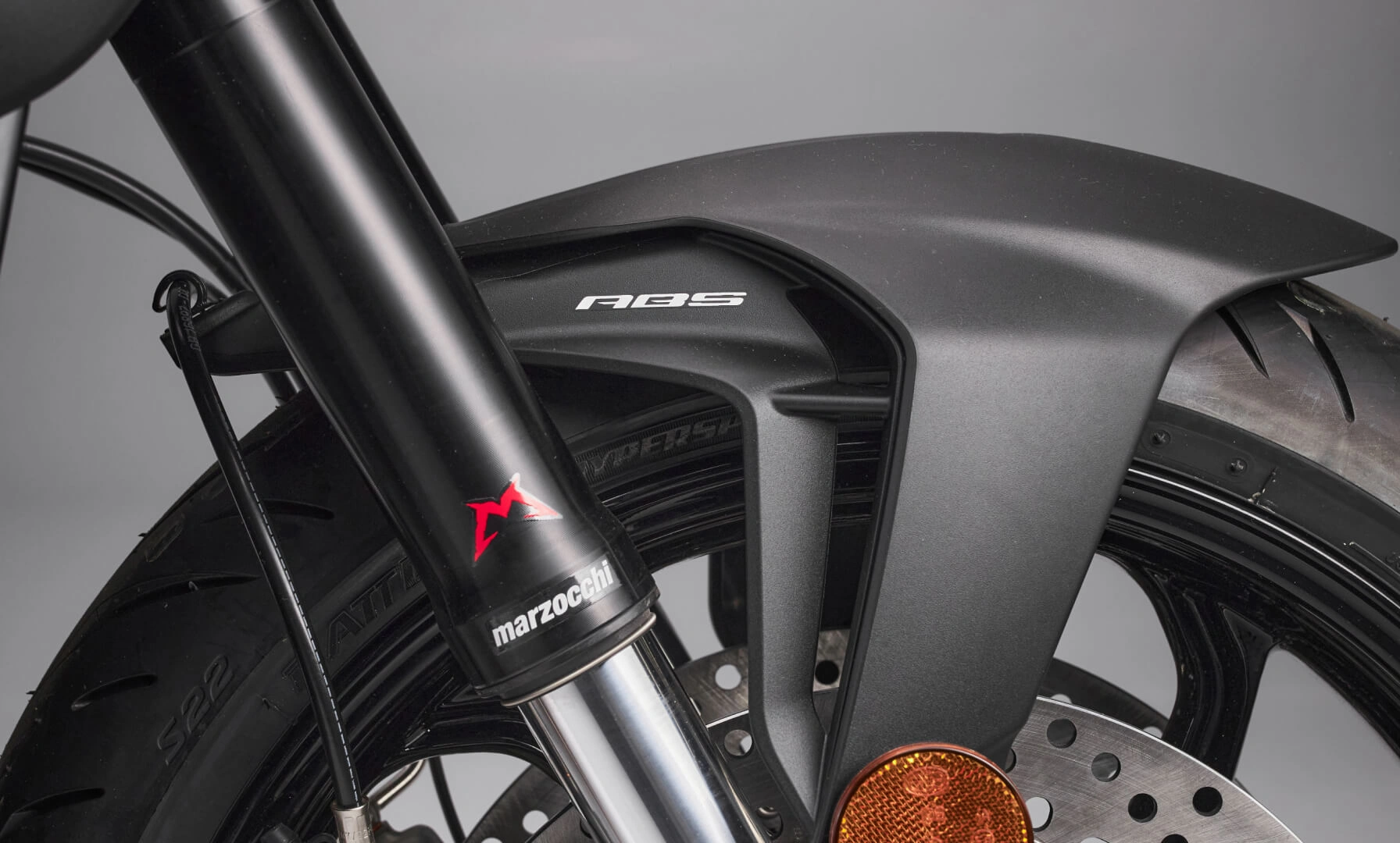 Nahaufnahme eines Motorradrads mit Bremsscheibe und "ABS"-Beschriftung.