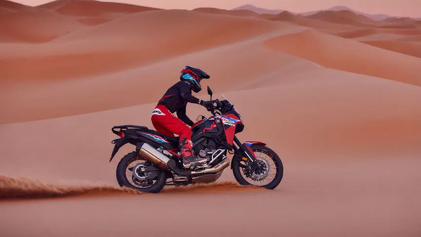 c4 (1) Ein Motorradfahrer fährt mit einer Honda Africa Twin durch eine Wüstenlandschaft.