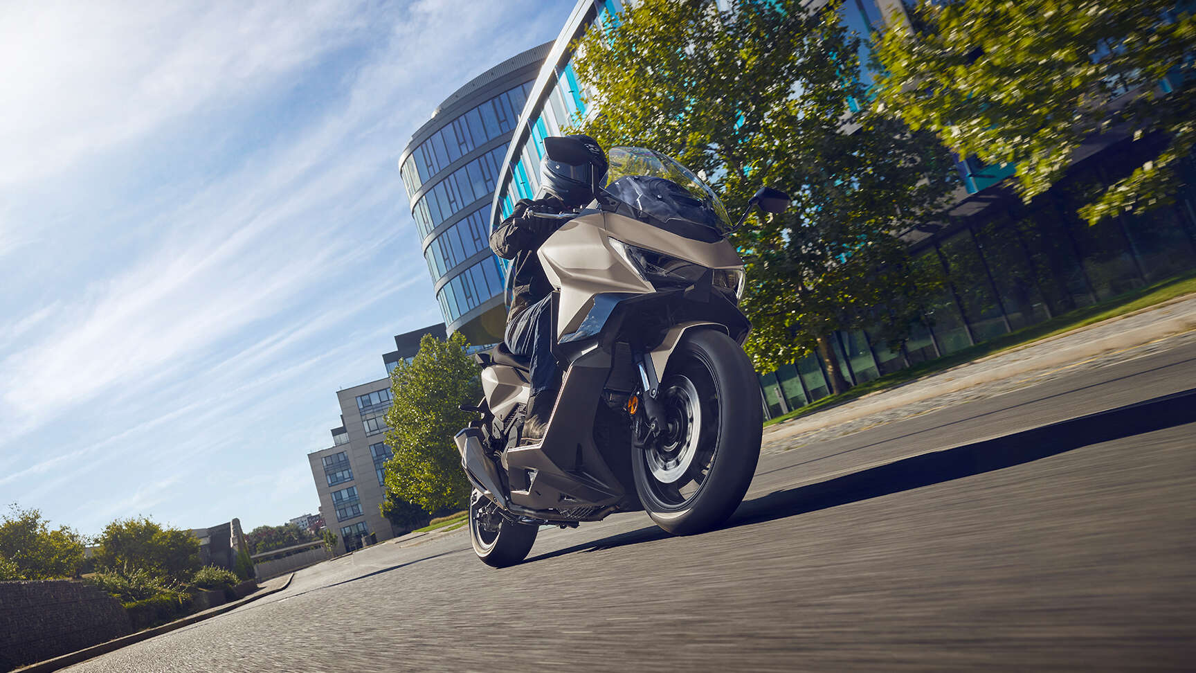 fb_r (1) Ein Motorradfahrer auf einem modernen Motorrad Honda FORZA 750 fährt durch eine Stadtlandschaft.