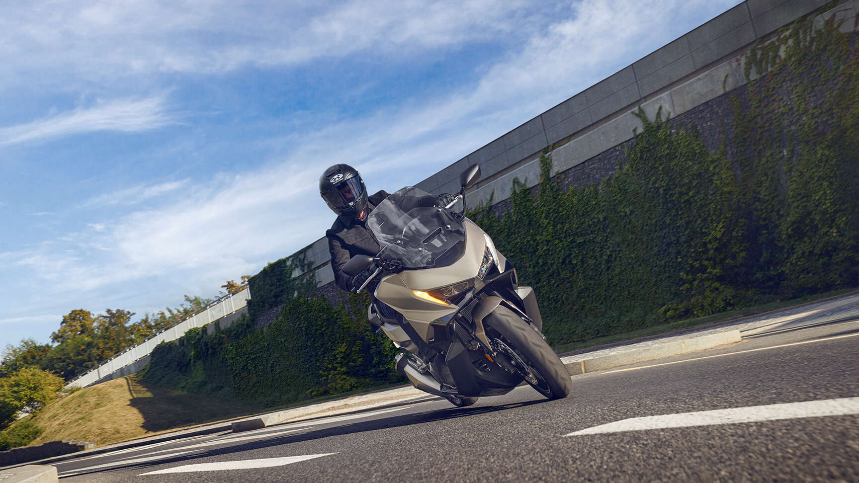 fb_r Ein Motorradfahrer fährt auf einem modernen Motorrad FORZA 750 auf einer Straße entlang.