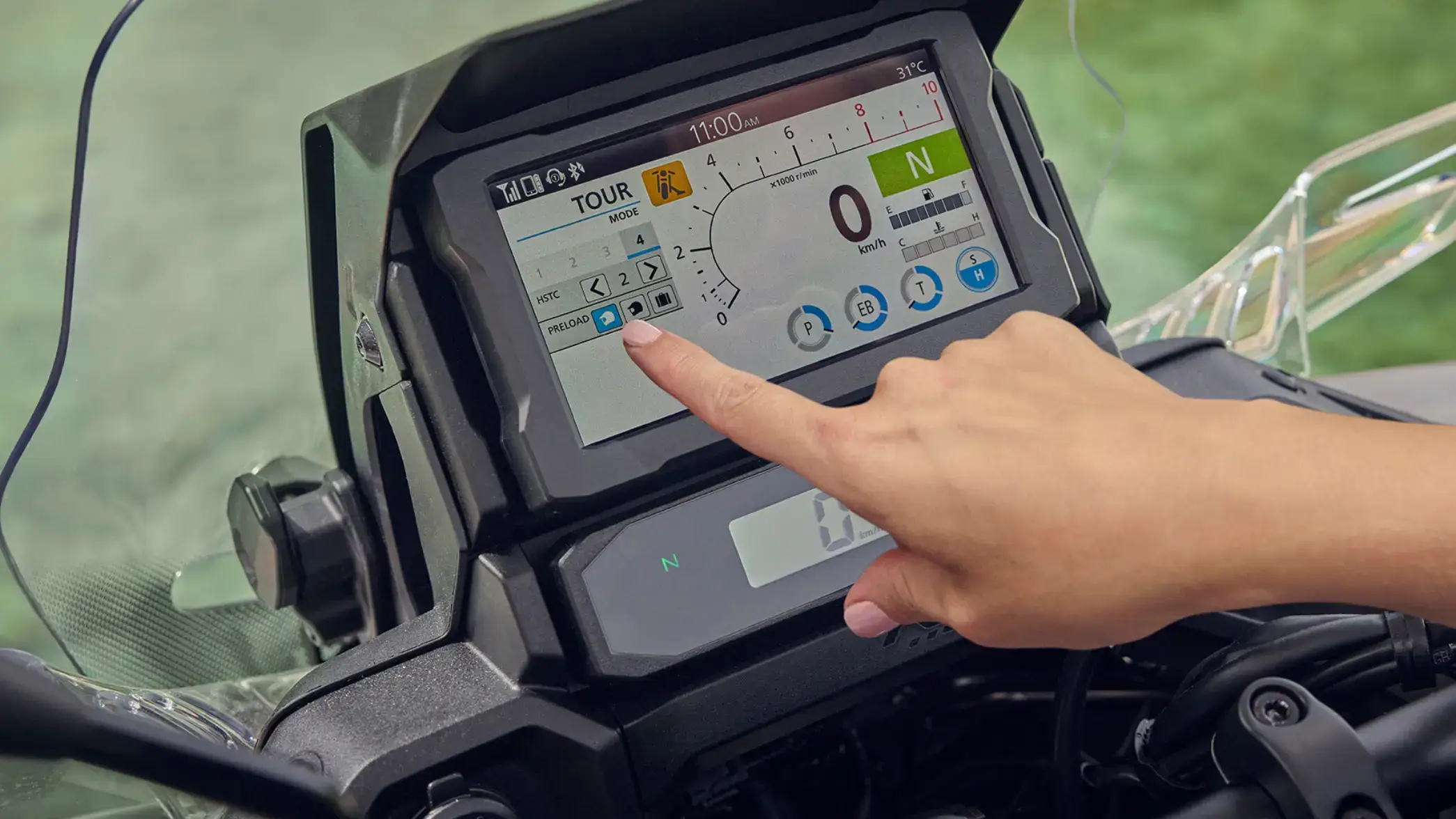 fb_r_w (1) Eine Hand berührt den Touchscreen eines Motorraddisplays zur Steuerung von Einstellungen.