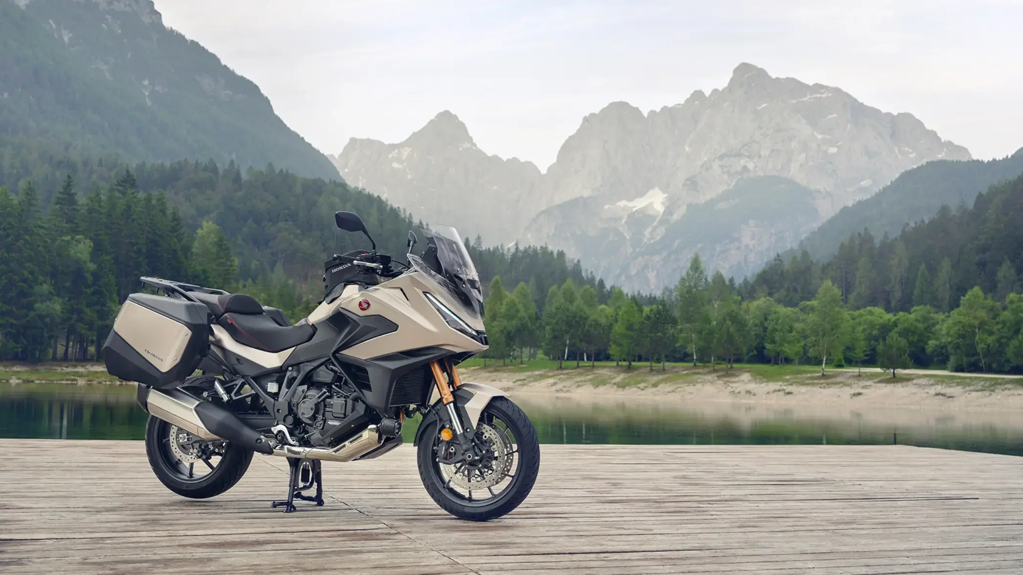 Eine Honda NT1100 steht auf einem hölzernen Steg vor einer Berglandschaft.