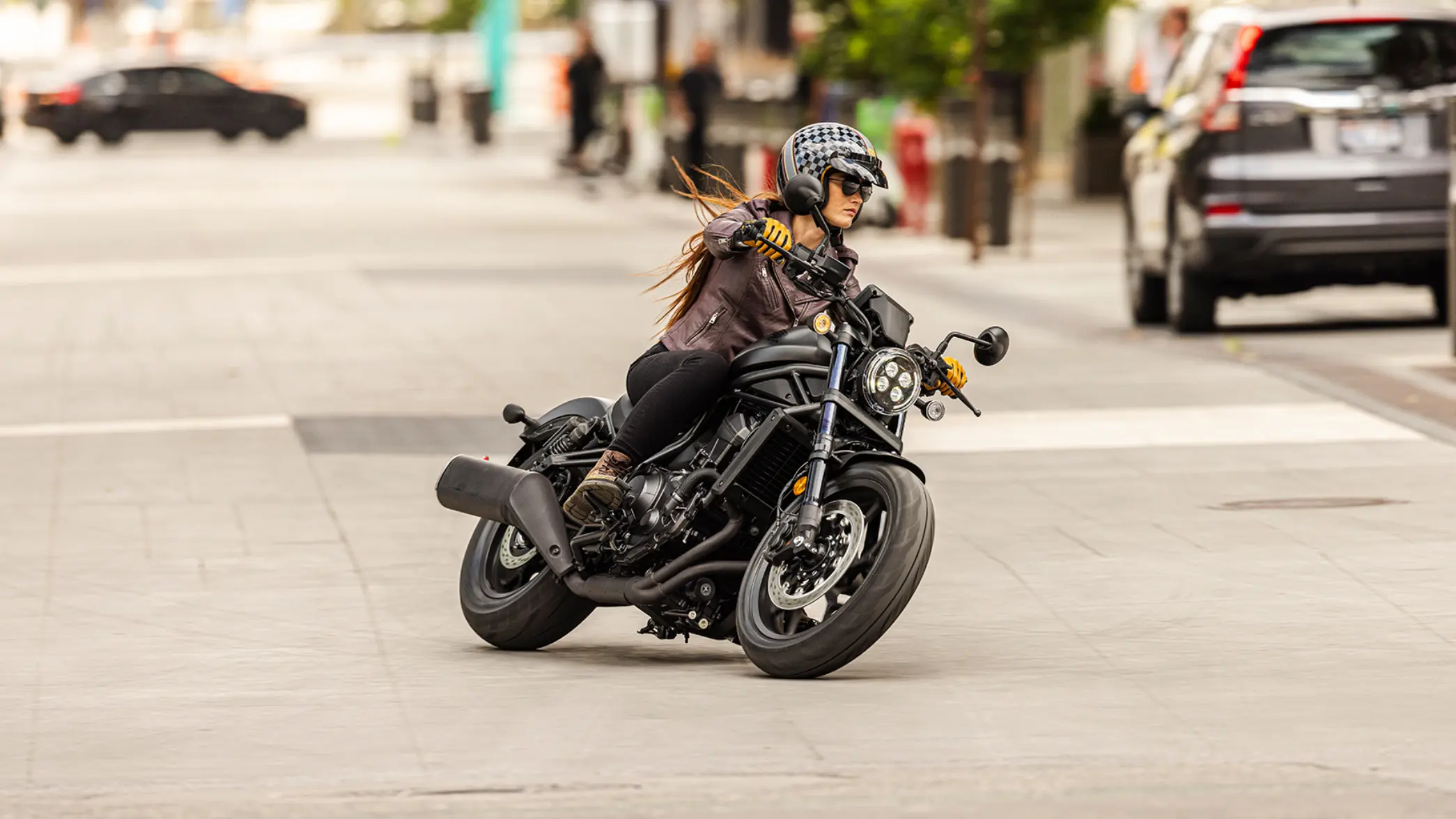 fb_r_w (2) - Kopie Frau fährt ein Honda CMX1100 Rebel Motorrad in der Stadt.