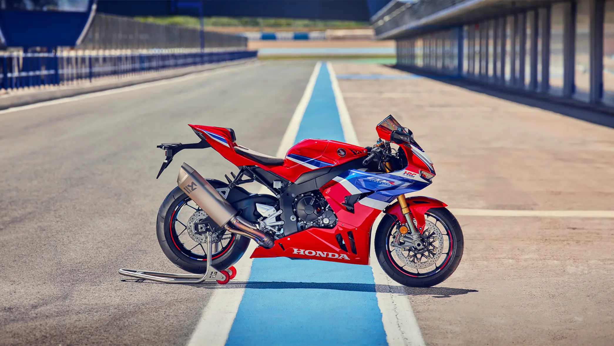 Ein rotes Honda-Motorrad steht auf einer Rennstrecke.
