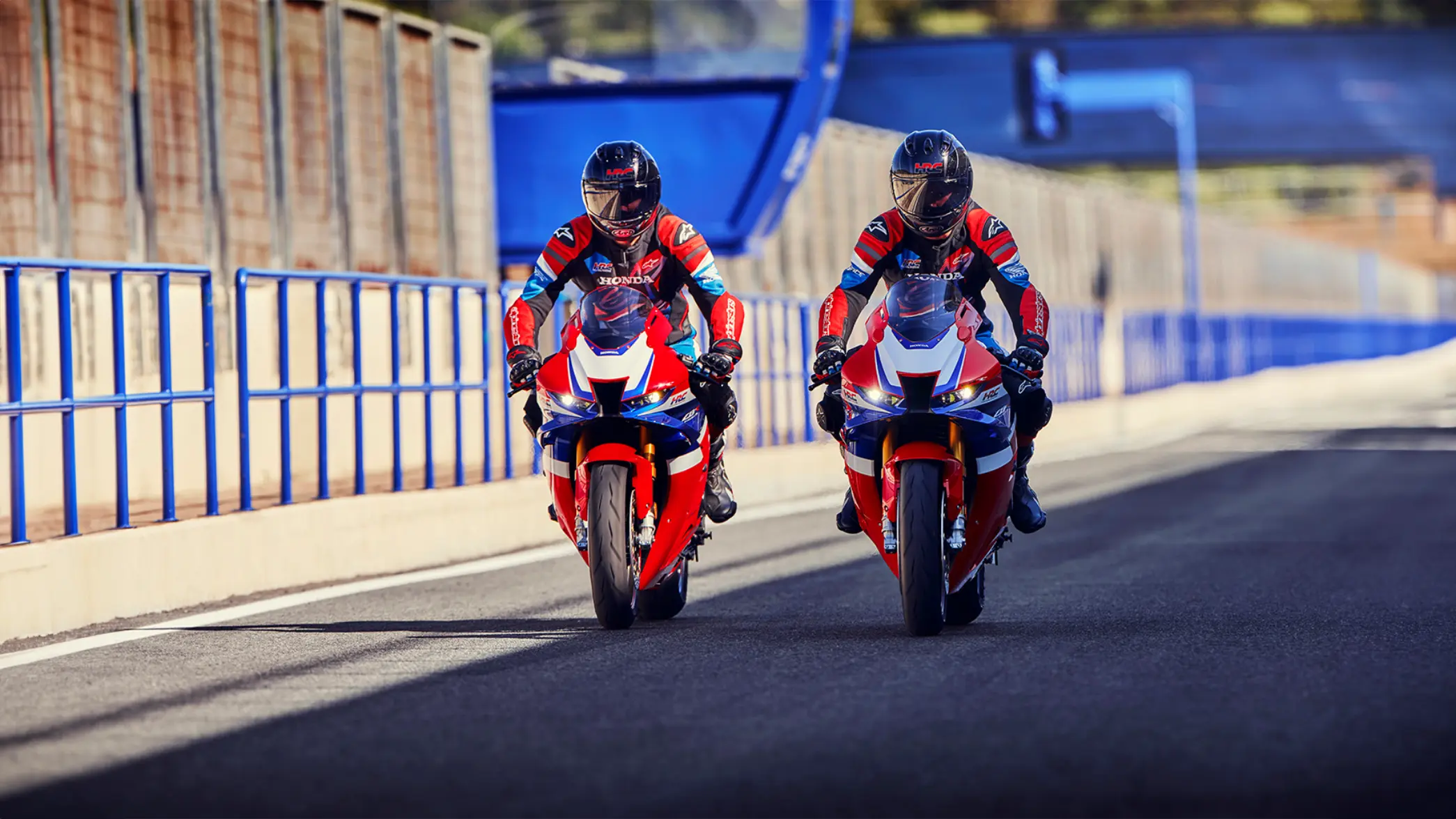 Zwei Motorradfahrer auf CBR1000RR-R Fireblades fahren nebeneinander auf einer Rennstrecke.